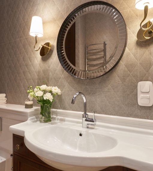 Modern fancy washroom design with round mirror and elegant sink in Karachi